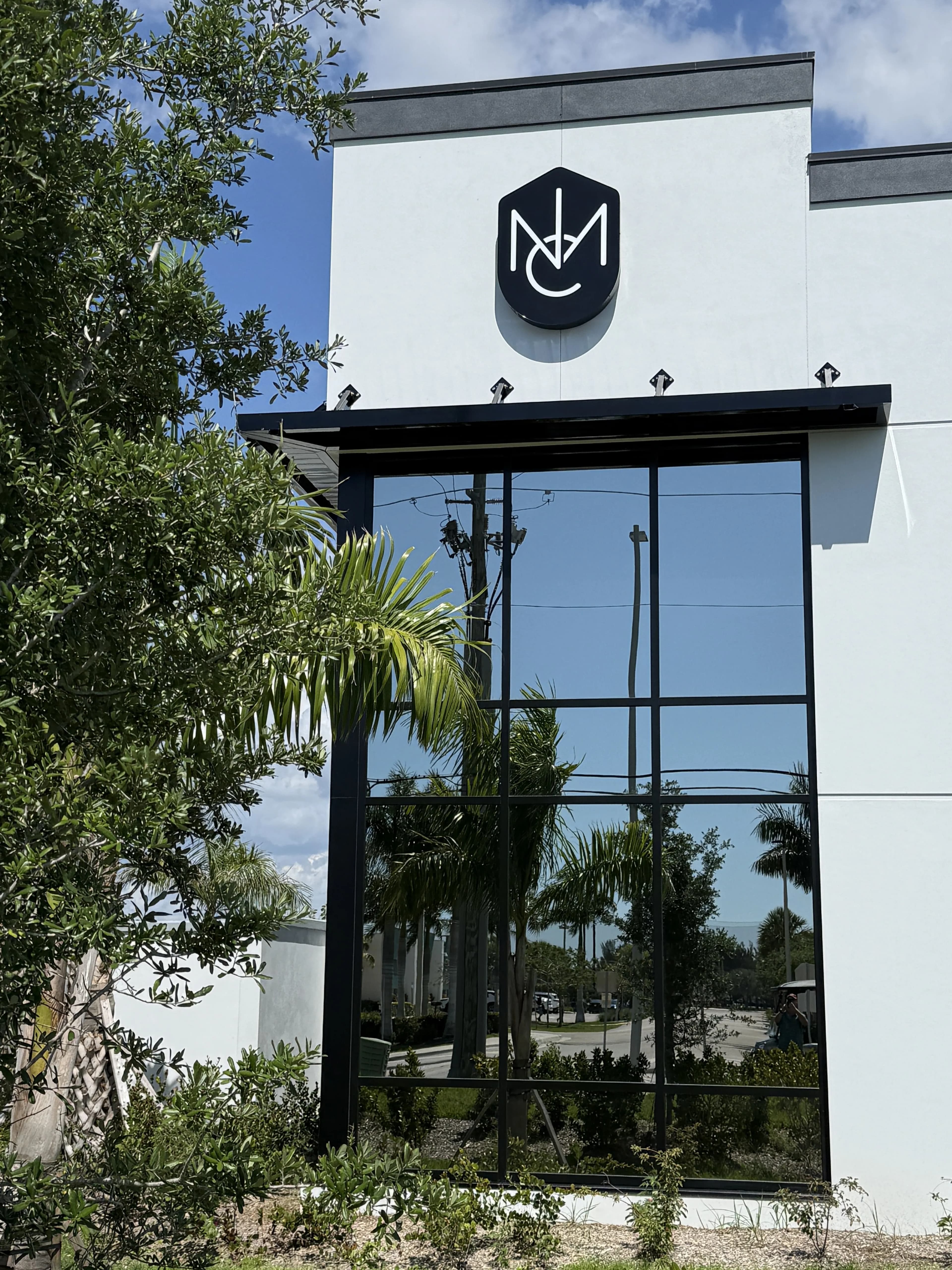 NMC clubhouse exterior with logo and glass facade