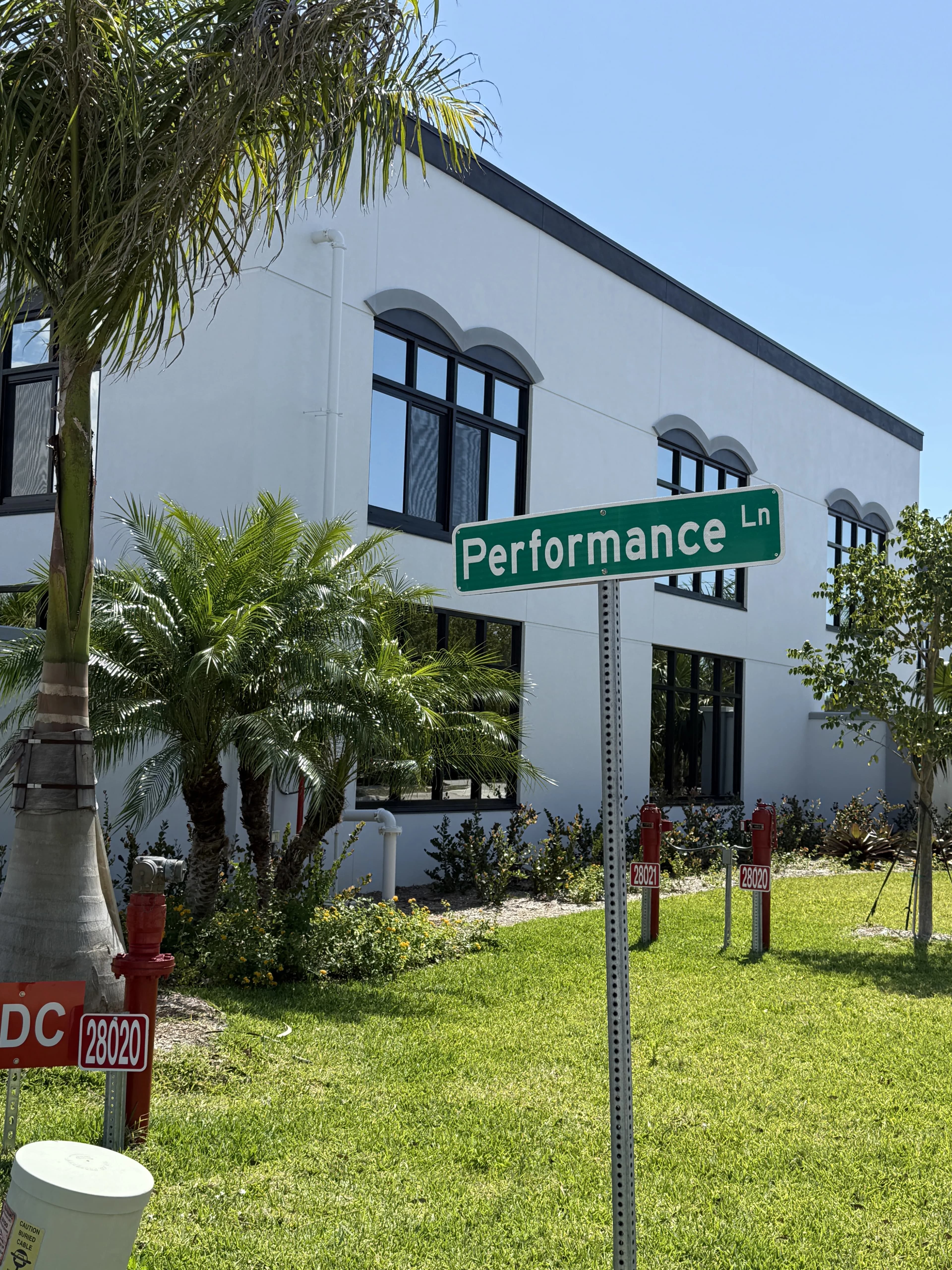 Performance Ln street sign with building and address 28020