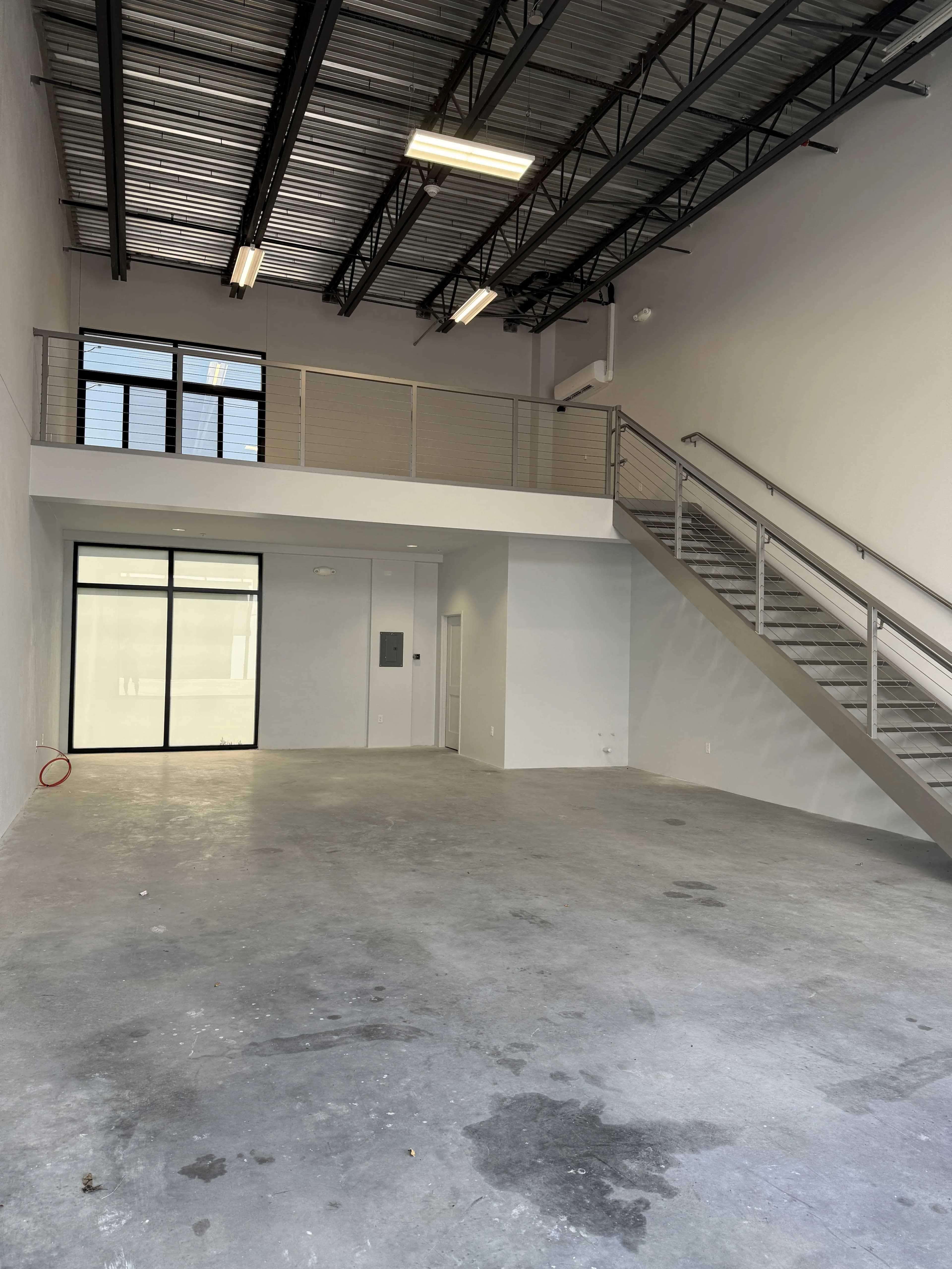 Garage floor alternate angle showing staircase and mezzanine railing