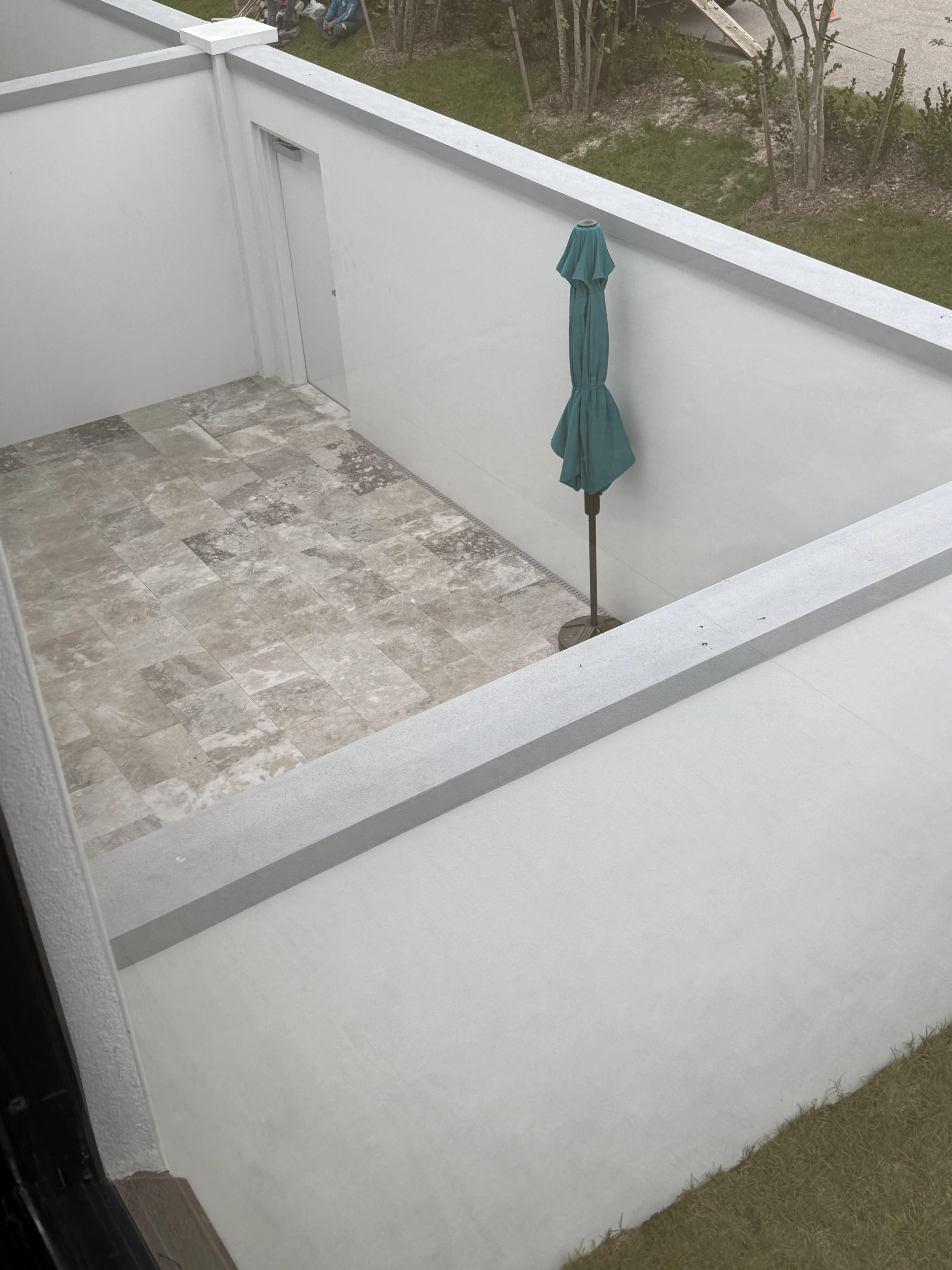 Private walled patio with stone tile and umbrella